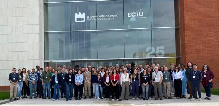 Rewrite consortium members standing outside a building.